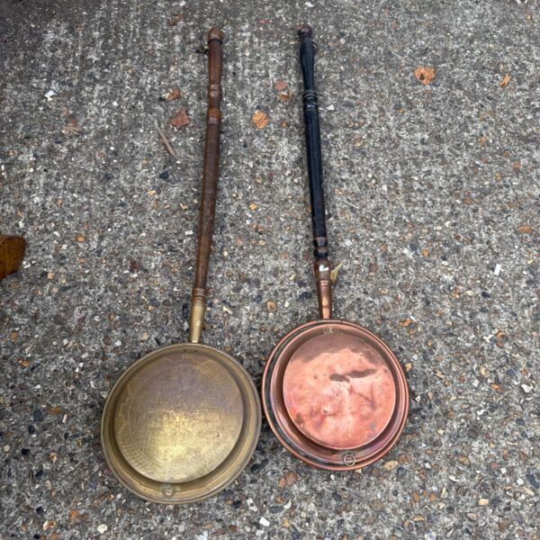 Vintage brass and copper chestnut roasting pans with long handles.