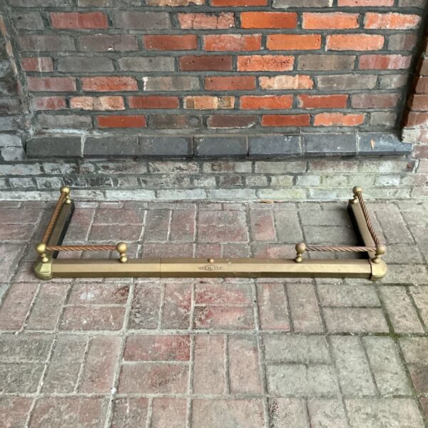 Vintage brass fireplace fender with barley twist design.