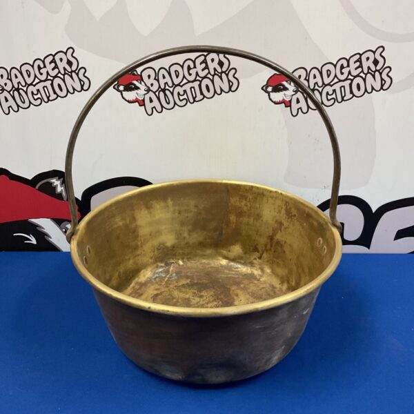 Large vintage brass jam pan with iron handle for cooking.