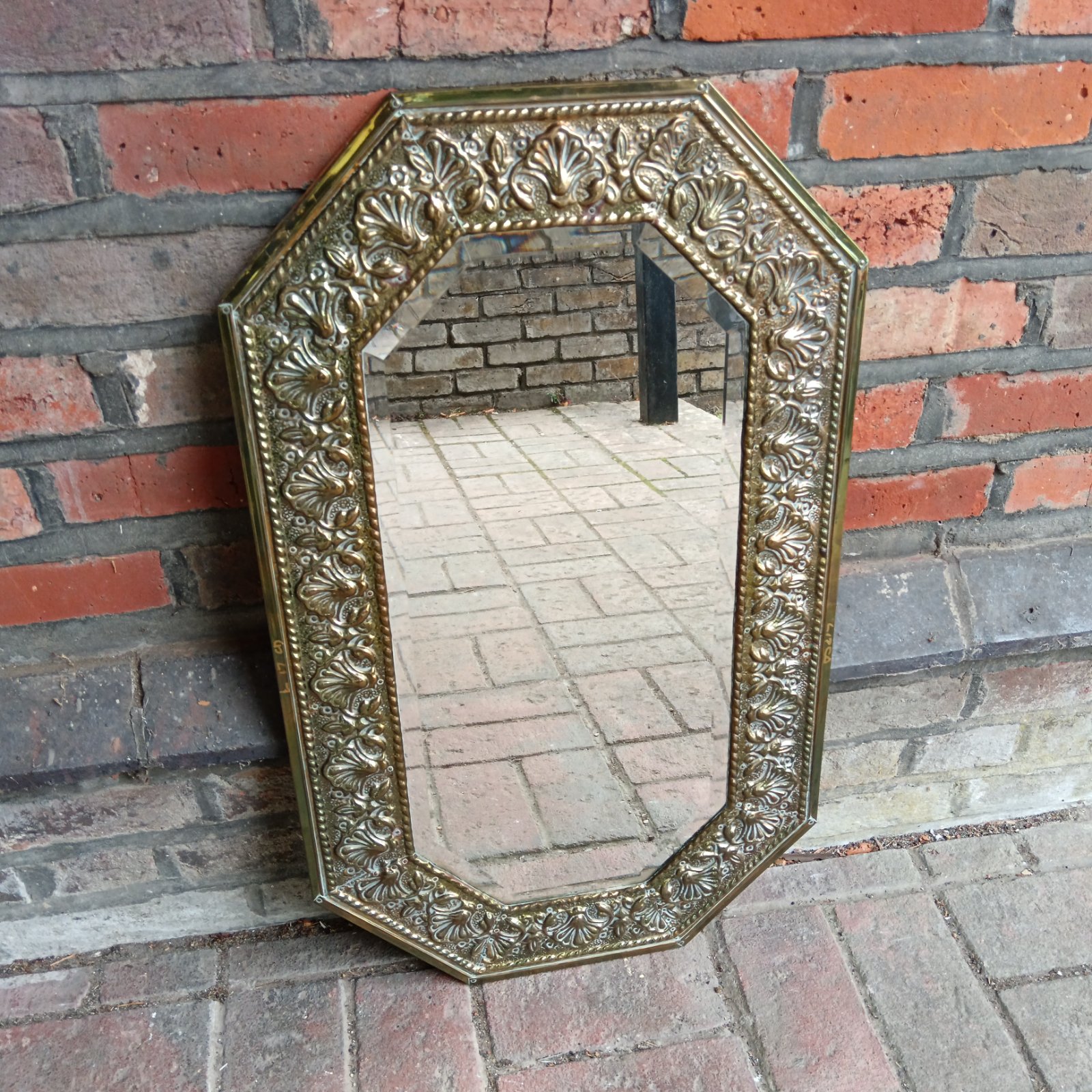 Ornate vintage brass mirror with bevelled edge.