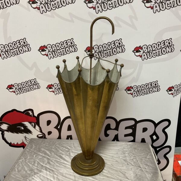 Vintage brass umbrella stand for hallway storage.