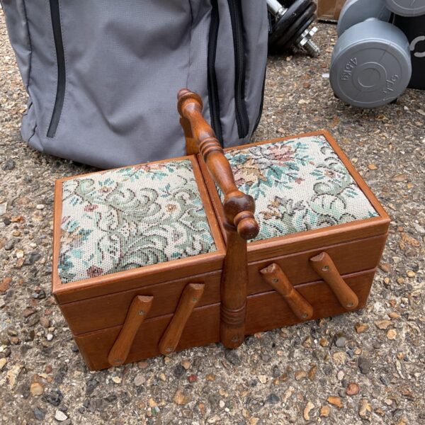 Vintage cantilever sewing box with patterned fabric and wooden handle.