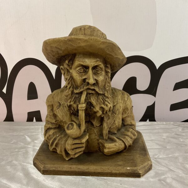 Vintage carved wooden bust of an old man smoking a pipe.