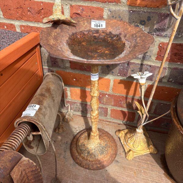 Vintage cast iron bird bath in a garden setting.