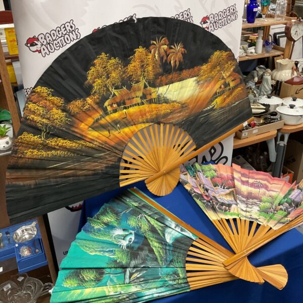 Vintage Chinese wall fans with hand-painted landscape scenes.