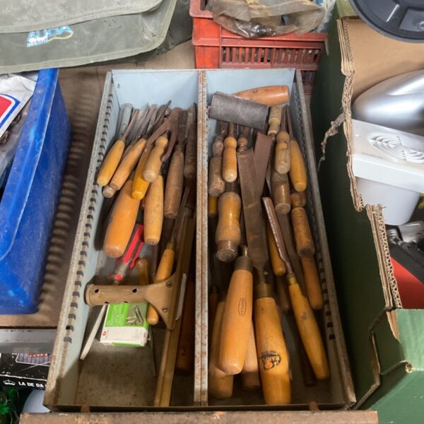 Vintage chisels in a metal rack, a collection of woodworking tools.