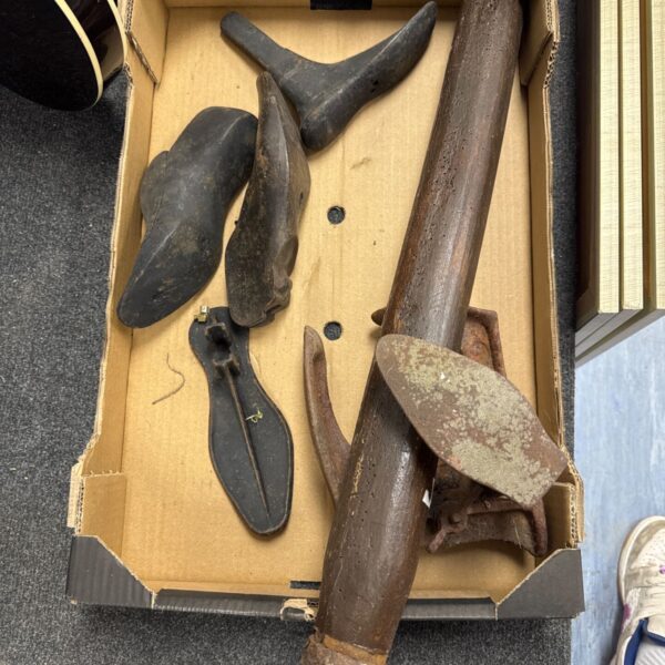 Vintage cobbler tools arranged on a tray, antique shoe repair.