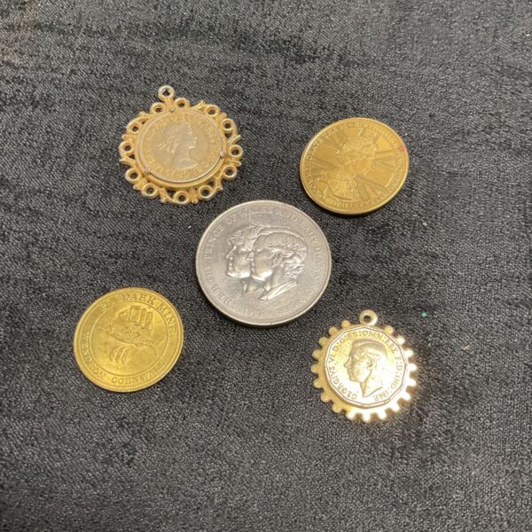 Group of vintage coin charms with gold tone finishes.