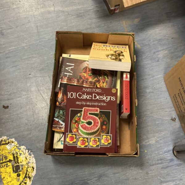 Stack of vintage cooking books in a cardboard box.