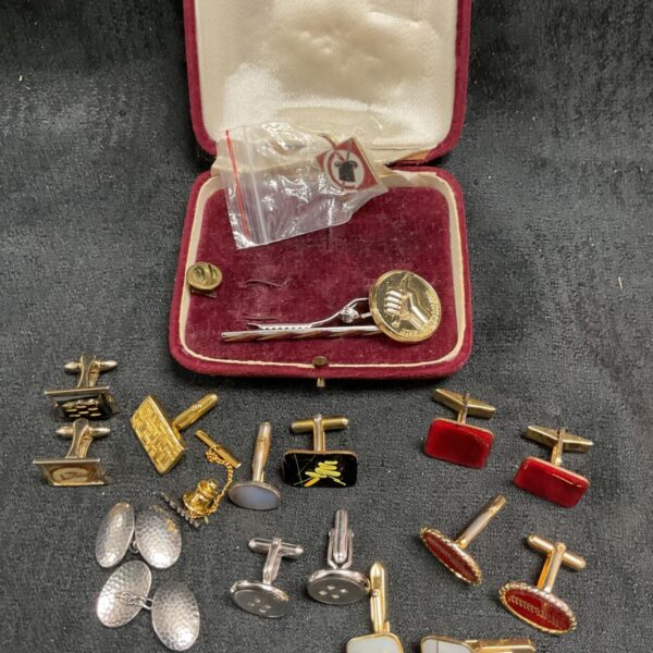 Vintage cufflinks, tie clips and pins collection on display.