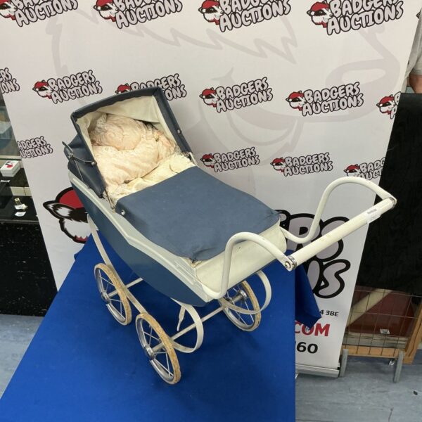 Vintage dolls pram with woven basket and spoked wheels.