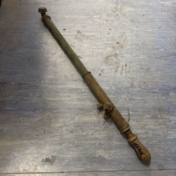 Vintage Dronwal brass sprayer on a grey surface.