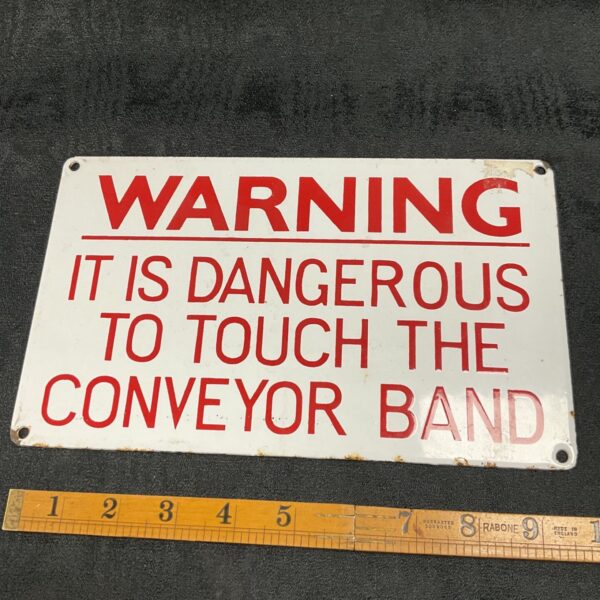 Vintage enamelled warning sign for conveyor belt safety.