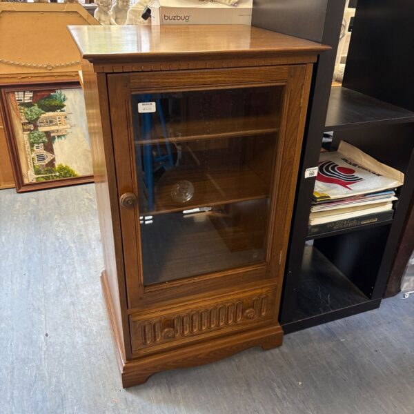 Vintage Ercol Hi-Fi cabinet with glass door and wood finish.