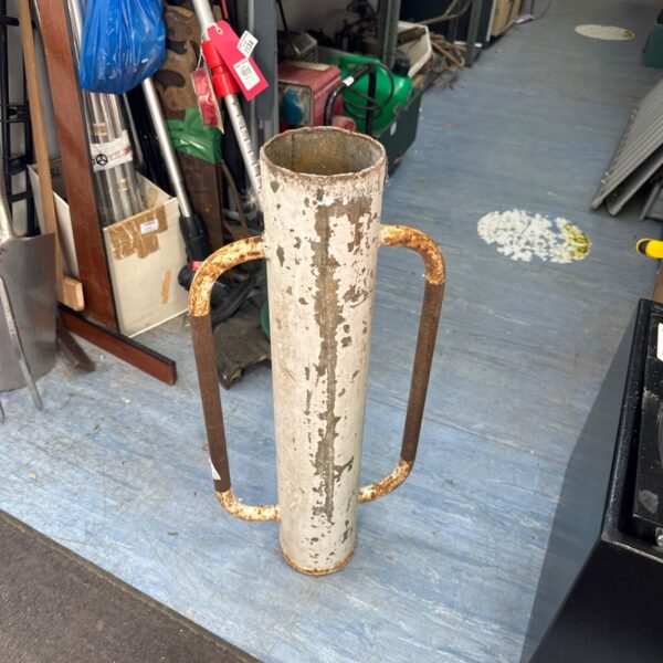 Vintage fence post boring tool with a rusted metal head and handle.