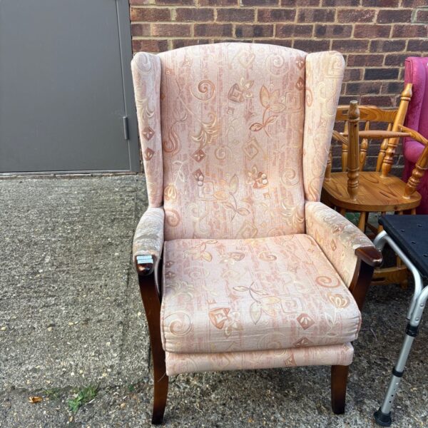 Vintage floral wingback armchair with wooden legs.