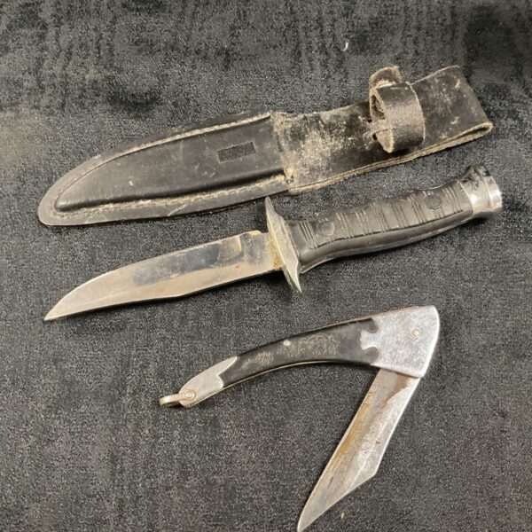 Vintage folding pocket knife with ebony handle and leather sheath.