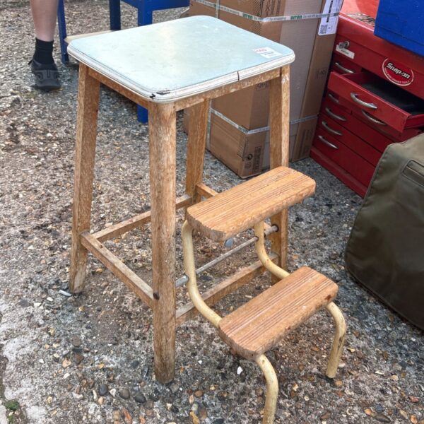 Vintage wooden folding step stool in a kitchen setting.