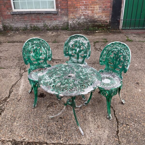 Vintage cast iron garden furniture set with floral detailing.