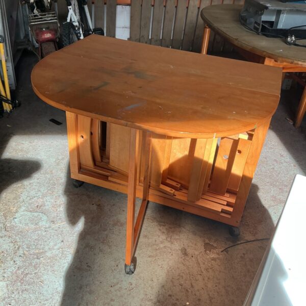 Vintage wooden gate leg table with folding leaves and castors.