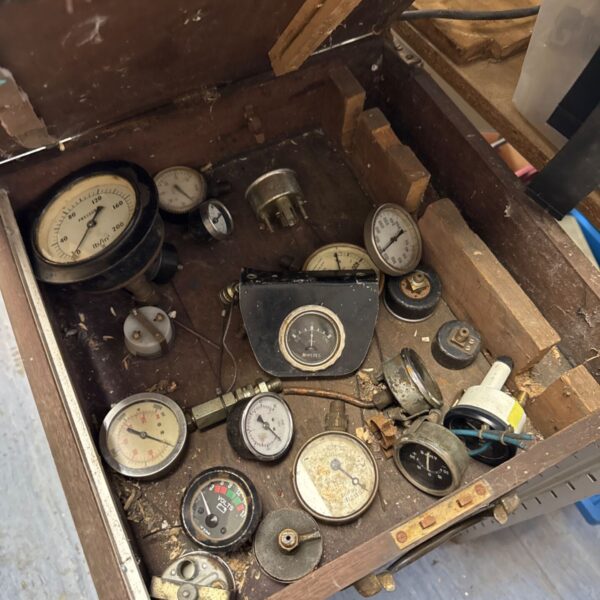 Open vintage wooden box filled with assorted gauges.