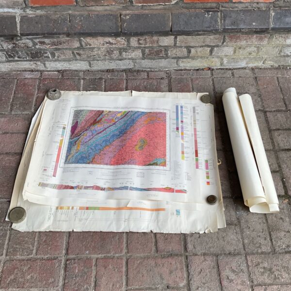 Vintage geological maps rolled on brick paving.