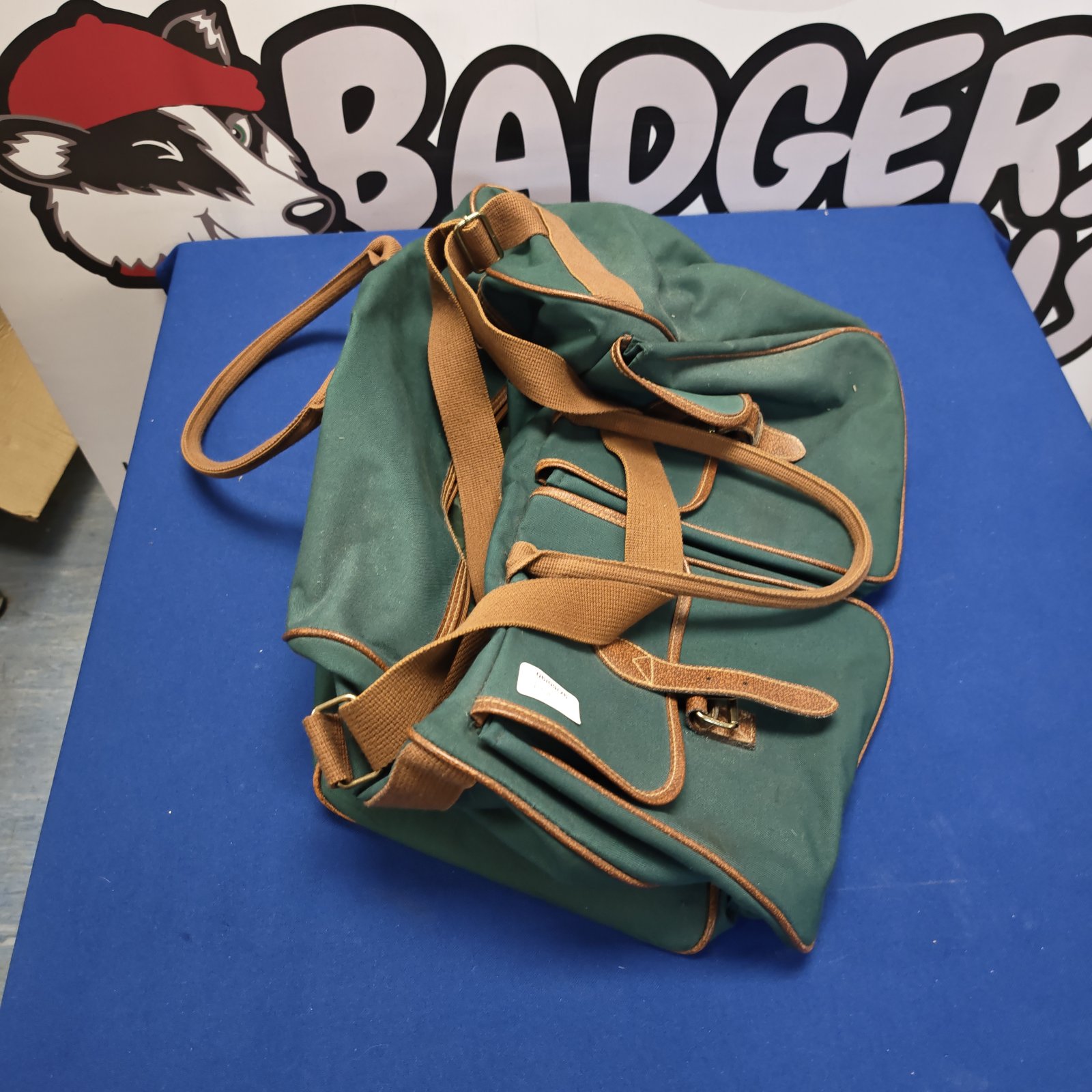 Vintage green canvas holdall with webbing straps.