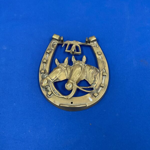 Vintage horse brass with a prancing horse design, antique equestrian decor.