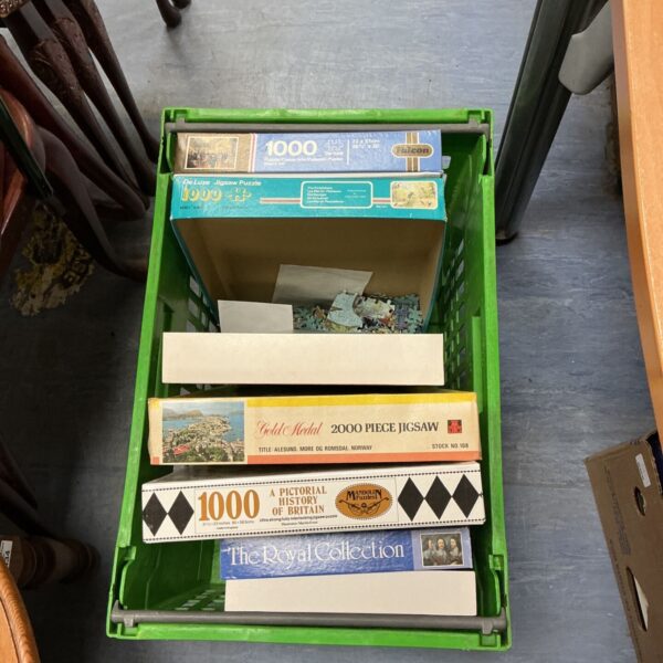 Vintage crate of jigsaw puzzles including Falcon and De Luxe brands.