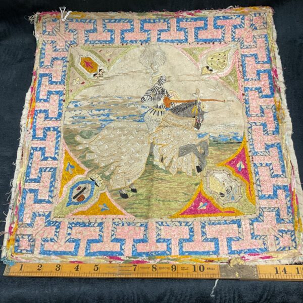 Vintage embroidered panel of a jousting knight with Greek key border.