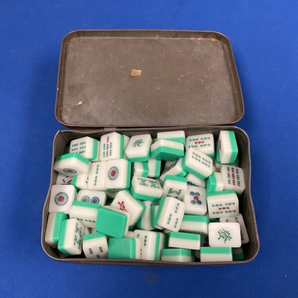 Vintage mahjong set with plastic tiles inside a metal tin.