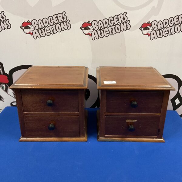 Pair of vintage mahogany drawers on a dark surface.