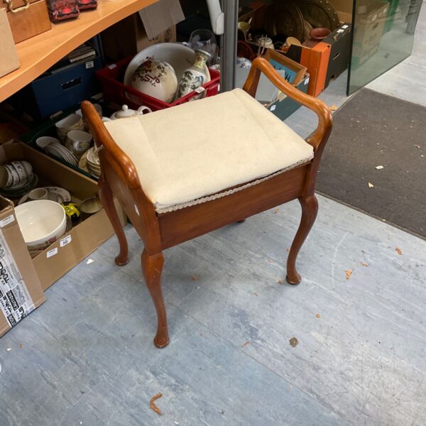 Vintage mahogany piano stool with adjustable height and upholstered seat.