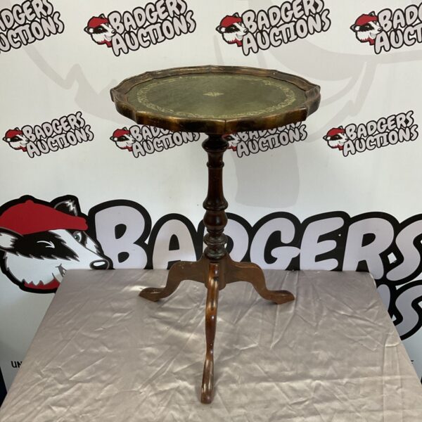 Vintage mahogany wine table with a leather top and curved legs.