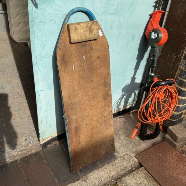 Vintage wooden mechanics crawler board in a workshop setting.