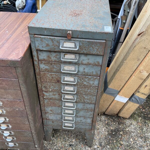 Vintage metal engineers cabinet with drawers, showing rust and patina.