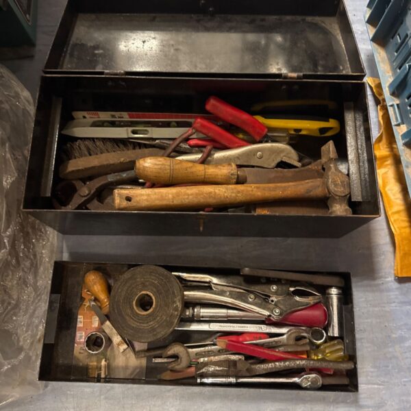 Vintage metal toolbox filled with antique hand tools.
