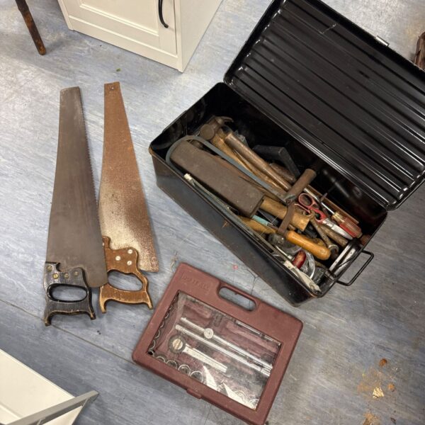 Vintage metal toolbox filled with a socket set and saws.