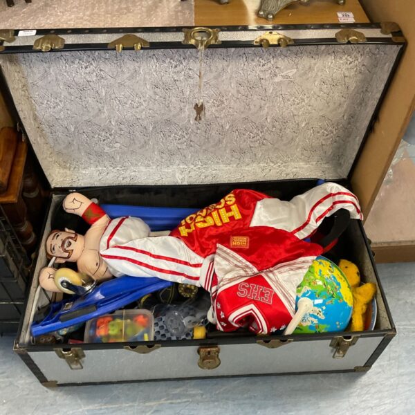Open vintage metal trunk filled with colourful toys.