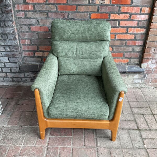 Vintage mid-century armchair with green upholstery and wooden legs.
