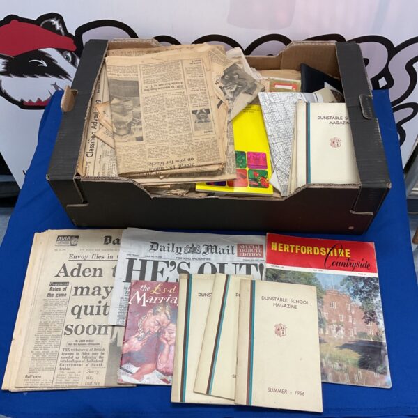 Vintage newspaper collection with a colourful magazine visible.