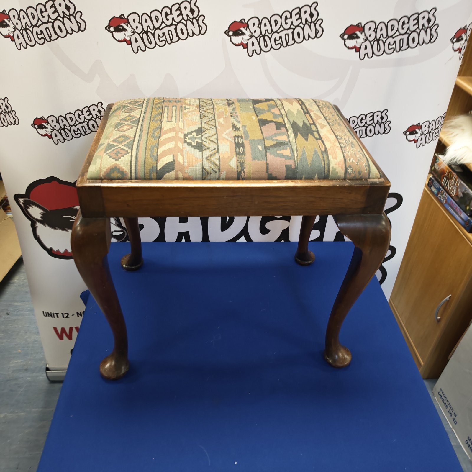 Vintage piano stool with oak legs and patterned upholstery.