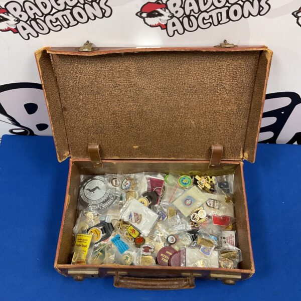Vintage pin badge collection displayed in a leather travel case.