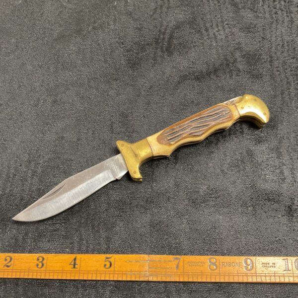 Vintage folding pocket knife with horn handle and brass bolsters.
