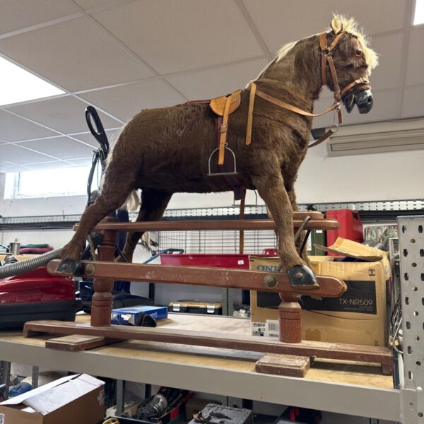 Vintage brown rocking horse on a wooden base.