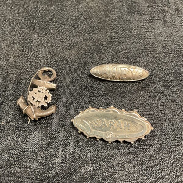 Vintage silver brooches including Sarah, Baby and a navy anchor.