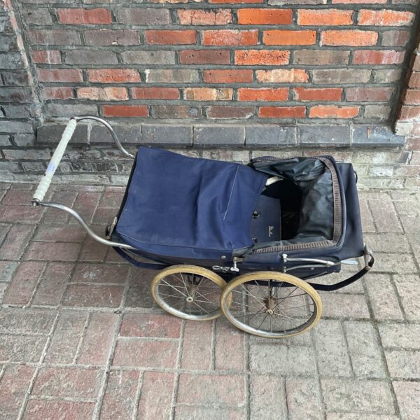 Vintage Silver Cross dolls pram with navy blue interior.