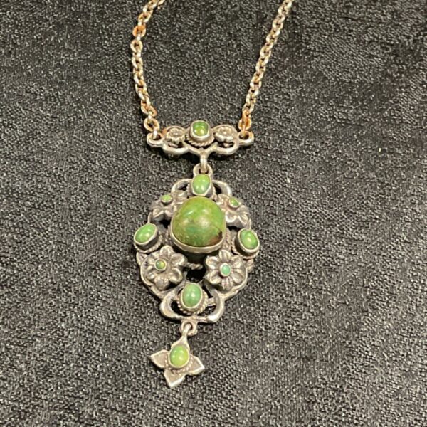 Close-up of vintage sterling silver pendant with jade cabochon.
