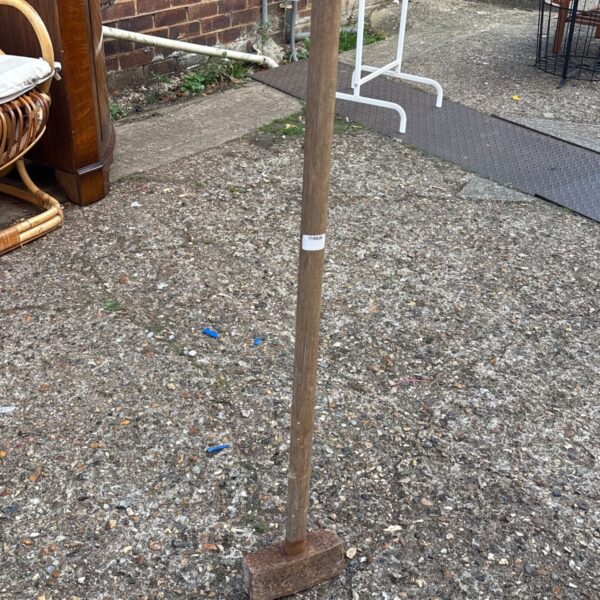 Vintage sledgehammer with a worn wooden handle and steel head.
