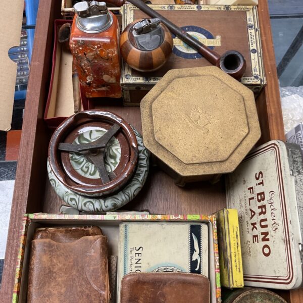 Vintage smoking collectibles including pipes and a tobacco jar.